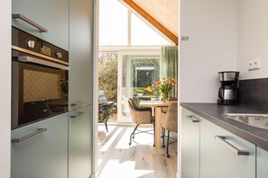 Una cocina moderna con comedor, ventanas amplias y vistas al exterior.