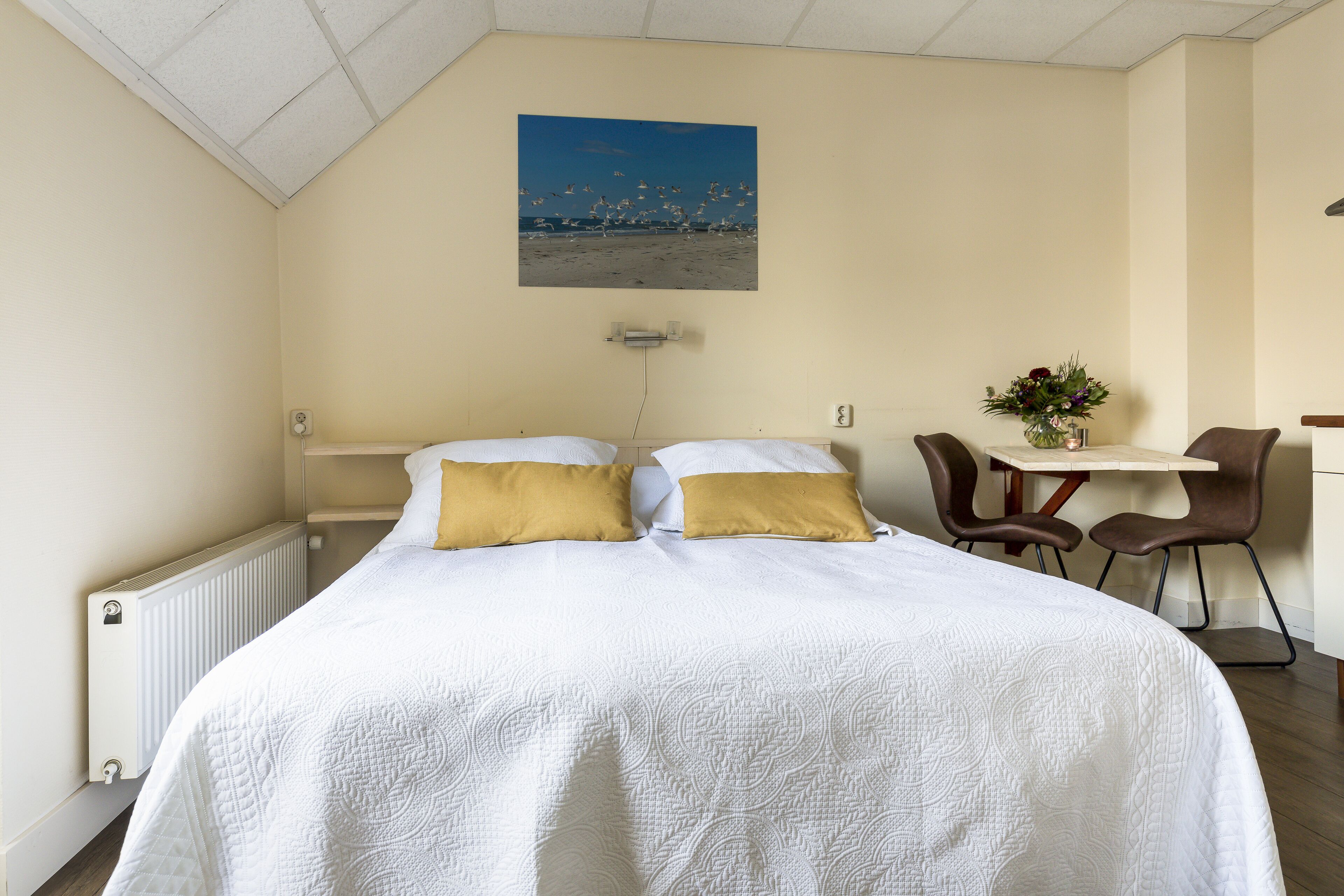 Una habitación de hotel con una cama, un escritorio y una silla.
