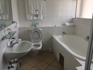 A bathroom with a toilet, bidet, sink, and bathtub. - The Enclave (Francistown)