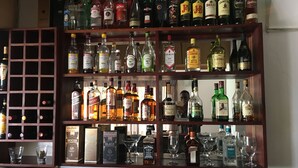 A bar area with multiple shelves of liquor bottles and glasses. - The Enclave (Francistown)