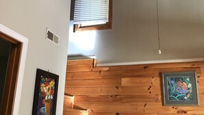 Una escalera de madera que sube a un segundo piso con una ventana en la parte superior.