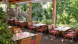 Eine Terrassenanlage mit Korbmöbeln, Tischen und Stühlen.