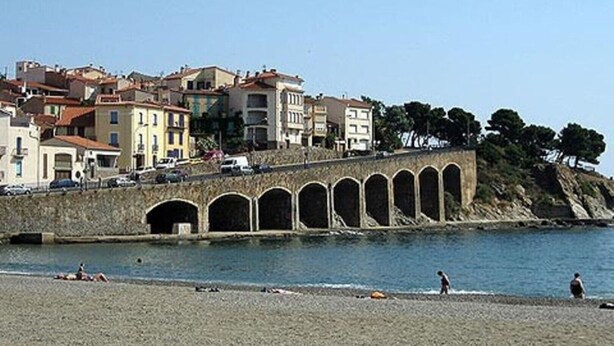 A stone bridge with arches leading to a coastal town with buildings and a beach. - APARTMENT T3 in villa 4 faces in BANYULS on sea PARKING CLOS (Banyuls-sur-Mer)