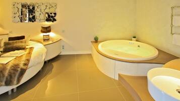 A modern bathroom with a bathtub, a sink, and a mirror.