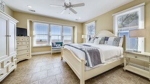A bedroom with a bed, a dresser, a TV, and a ceiling fan. - JonBie Maison Ocean Serenity Cottage  Oceanfront Cart included with Booking. (Daufuskie Island)