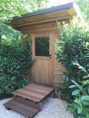 Eine Holzhütte mit Tür und kleiner Veranda.