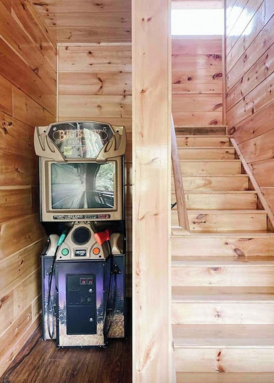 A narrow wooden cabin with a small staircase and a mounted television.