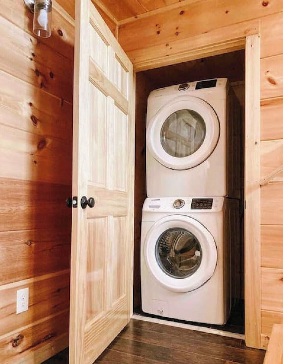 Un intérieur en bois avec un lave-linge double dans une petite pièce.