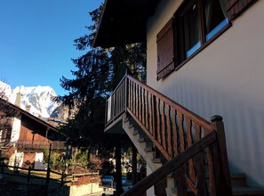 A staircase leading to a balcony with a mountain view in the background.