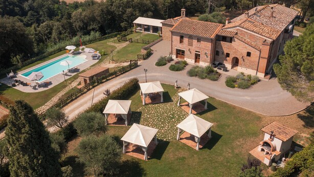 Eine großzügige Villa mit Swimmingpool, Sitzgelegenheiten im Freien und einem gepflegten Garten.