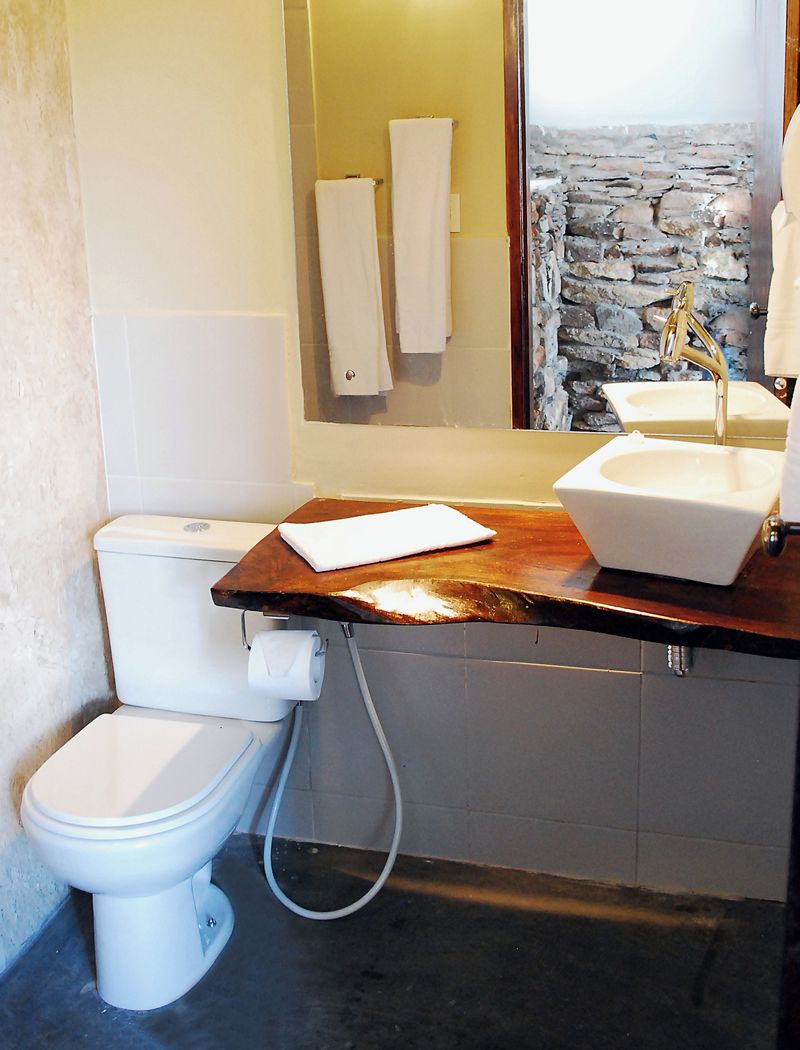 A bathroom with a toilet, sink, and mirror.