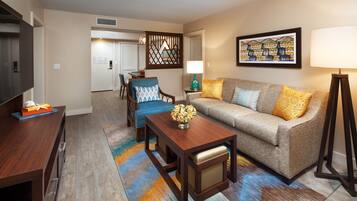 A living room with a sofa, a coffee table, a TV, and a lamp.