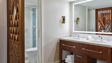 A modern bathroom with a wooden vanity, two sinks, and a large mirror.