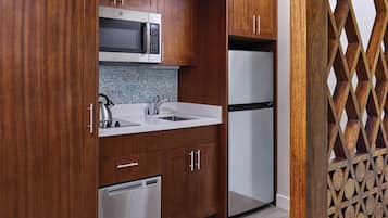 A kitchen with wooden cabinets, a microwave, a refrigerator, and a dishwasher.