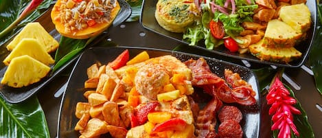Diversos platos, incluyendo plátanos fritos, una ensalada de lechuga y tomates, y un plato con plátanos fritos y carne.