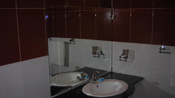 Ein Badezimmer mit zwei Waschbecken, einem Spiegel und einem Handtuchhalter.
