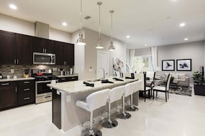 A modern kitchen with dark cabinetry, a stainless steel microwave, and a granite countertop.
