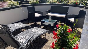 A patio with outdoor furniture, a glass table, and a lantern. - Apart Matthias (Mayrhofen)
