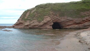 A coastal landscape with a rocky cliff and a cave entrance. - Bright, spacious centrally-located 3-bedroomed house with ample free parking. (Stirling)