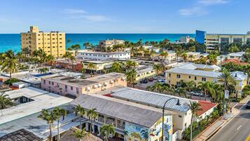 A coastal town with buildings, palm trees, and a view of the ocean.