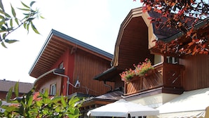A wooden building with a balcony and a white awning. - Apartment Dahoam (Forstau)