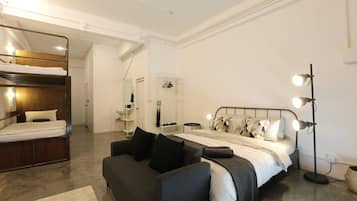 Habitación cuádruple | Artículos del minibar gratis, escritorio y cortinas blackout