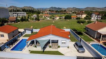 A residential area with houses, a swimming pool, and a view of mountains.