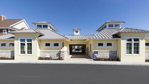 A modern building with a central entrance, stone facade, and multiple windows. - ★Amazing Hidden Gem | Min ➡️ Disney | ❤ 139 (Kissimmee)
