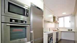 A modern kitchen with stainless steel appliances, a built-in oven, microwave, and dishwasher. - Gabriel 01 by Interhome (Calpe/Calp)