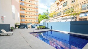 A swimming pool with a tiled deck, lounge chairs, and potted plants. - Gabriel 01 by Interhome (Calpe/Calp)
