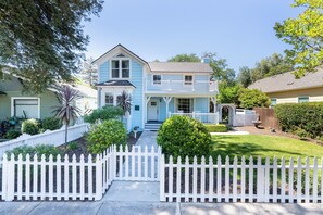 A two-story house with a front porch, a white picket fence, and a well-maintained lawn. - Victorian Charm + BBQ Yard | Paso Robles Wine Country | Vacations on Vine (Paso Robles)