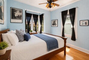A bedroom with a bed, a ceiling fan, and a window with curtains. - Victorian Charm + BBQ Yard | Paso Robles Wine Country | Vacations on Vine (Paso Robles)
