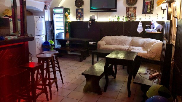 A cozy living area with a sofa, a coffee table, and a TV mounted on the wall. - Whole basement former pub 4 stag do (VIII. kerület)