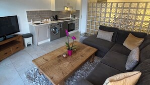 A modern living room with a sofa, a coffee table, and a TV.