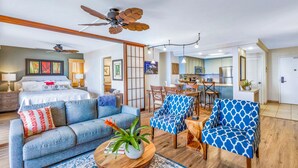 Ein modernes Wohnzimmer mit einer Couch, Sesseln, einem Couchtisch und einem Essbereich.