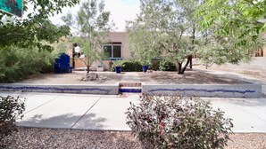 A courtyard with a building, trees, and a blue-tiled planter. - Gorgeous, private, comfy, clean & close to EDO (Albuquerque)