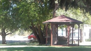 A gazebo in a park with a lawn and trees. - Cedar Village Motel (Spokane)