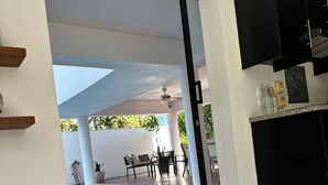 Un intérieur moderne avec un espace piscine, un coin repas et un magazine posé sur la table.