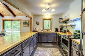 A kitchen with wooden countertops, dark cabinets, a built-in oven, and a large window. - On 7 Acres, Sleeps 16, HUGE Gameroom, Hot Tub, Near Slopes (Banner Elk)