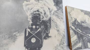 Fotografía antigua en blanco y negro de una locomotora de vapor sobre rieles, con un fondo desenfocado.