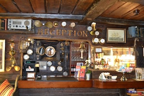 A reception area with a wooden ceiling, various clocks, and a sign that reads 'RECEPTION'. - The Red Boat (Stockholm)