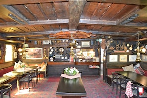 A bar area with wooden ceiling beams, a bar counter, and various bar equipment. - The Red Boat (Stockholm)