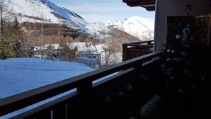 En balkon med udsigt over et sneklædt bjerglandskab.