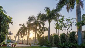 Un jardín bien cuidado con palmeras y un letrero de hotel.