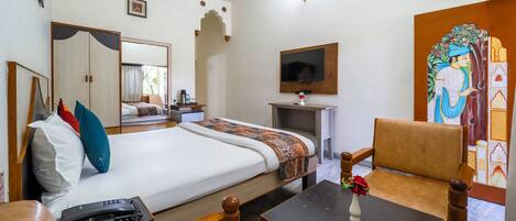 A hotel room with a bed, a desk, a chair, a television, and a decorative painting.