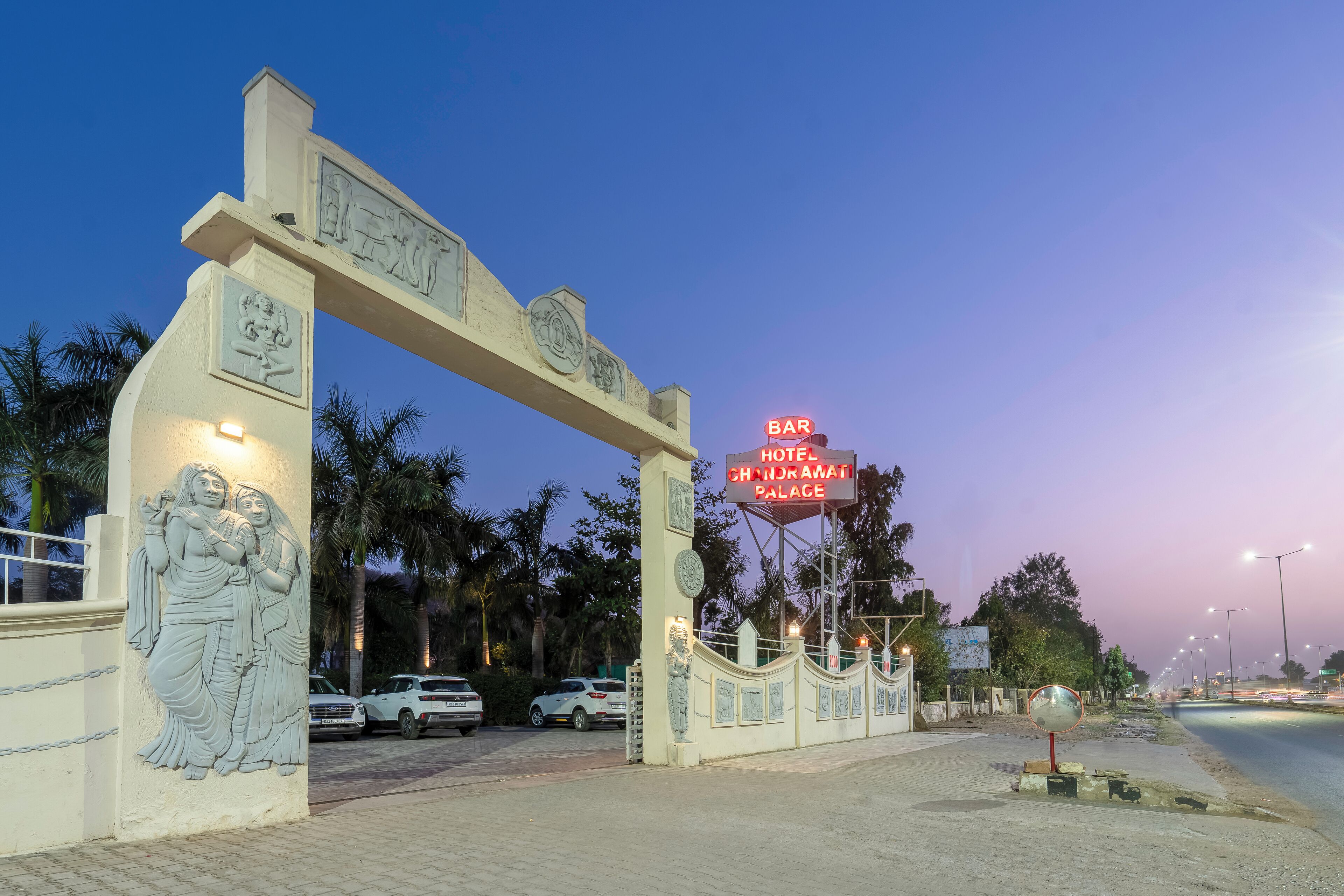 Entrada de hotel con un gran arco y un letrero que indica que es un hotel.