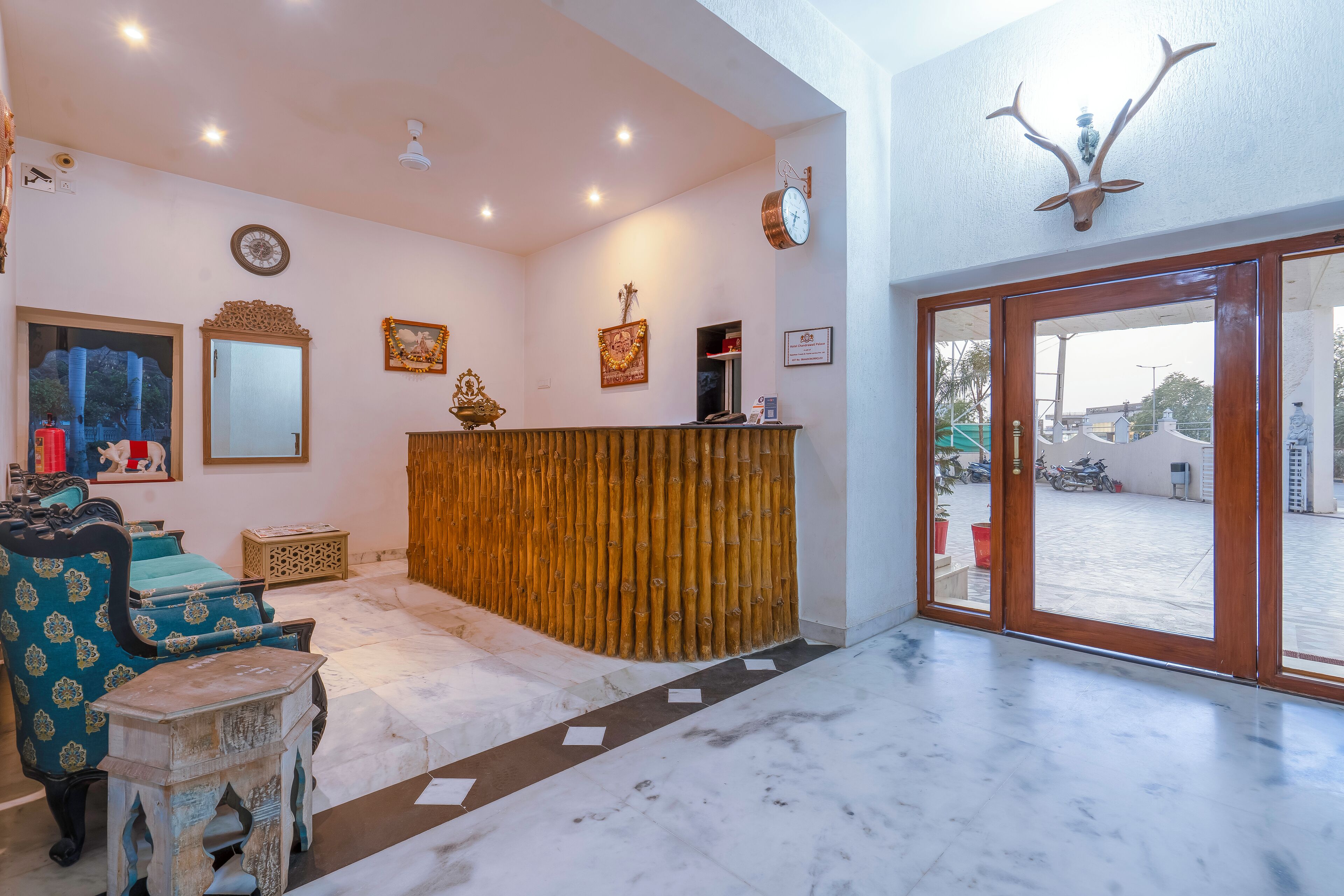A reception area with a wooden counter, a mirror, framed pictures, and a large window with a view of the outside.