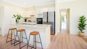 Eine moderne Küche mit einer zentralen Kochinsel, Edelstahlgeräten und Holzbarhocker.