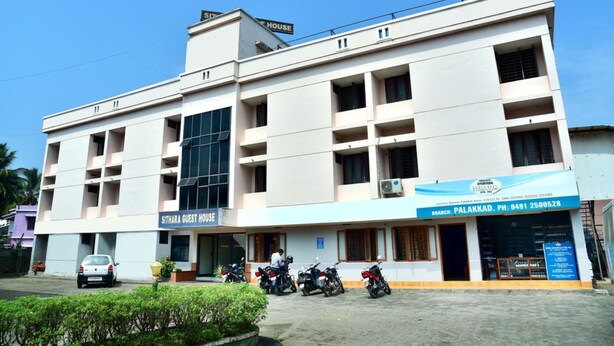 A multi-story building with a sign for "Sithara Guest House" and a branch of "Sithara Bank" on the ground floor. - Sithara Guest House (Palakkad)