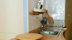 Een keuken met een houten aanrecht, een spoelbak en een spatwand.